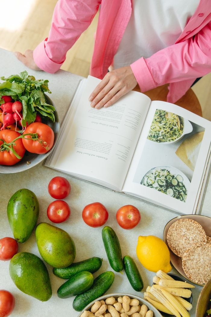 Mastering the First Impression: Your intriguing post title goes here Overhead view of fresh vegetables and an open cookbook on a kitchen counter.